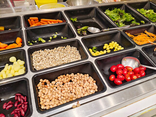 Fresh Vegetables and Beans Selection on Salad Bar Display in Black Containers Ready for Buffet Style Healthy Eating