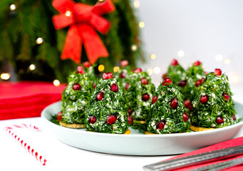 A delicious New Year's salad of chicken, cheese, eggs and garlic, shaped like a Christmas tree and garnished with dill and pomegranate seeds. Close-up. Selective focus.