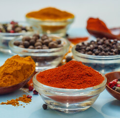 Orange paprika in bowl on blue blurred backdrop. Food seasoning texture. Seasonings vibe.