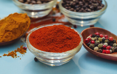 Orange paprika in bowl on blue background. Food seasoning texture. Seasonings vibe.