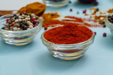 Orange paprika in bowl on blue background. Food seasoning texture. Seasonings vibe.