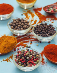 Сolored peppers in bowl on blue background. Texture of food seasonings close-up. Vibe of spices.