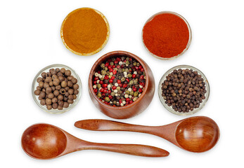 Top view of spice composition in bowls and spoons. Colorful Indian and Asian seasonings on white.