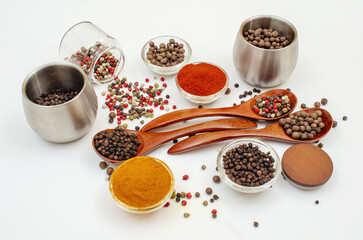 Spice composition in bowls and spoons. Colorful Indian and Asian seasonings on white. Culinary site.