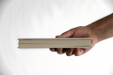 Hand holding a book isolated on white background