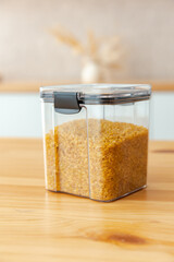 Filled groats plastic containers on the kitchen background