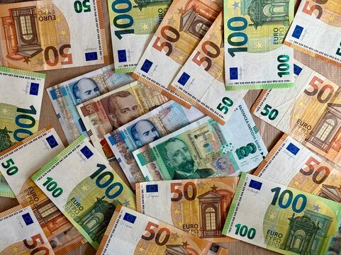 Euro banknotes mixed with Bulgarian lev notes, symbolizing upcoming currency shift in Bulgaria starting 2026. Concept of eurozone expansion and Bulgarian euro integration