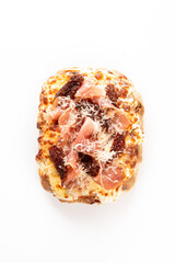 A delicious pizza-like open-faced sandwich with melted cheese, prosciutto, and sun-dried tomatoes, topped with grated parmesan cheese