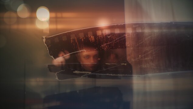 Suspending torn film strip revealing human face fragment at abstract studio, with bokeh lights - Powered by Adobe