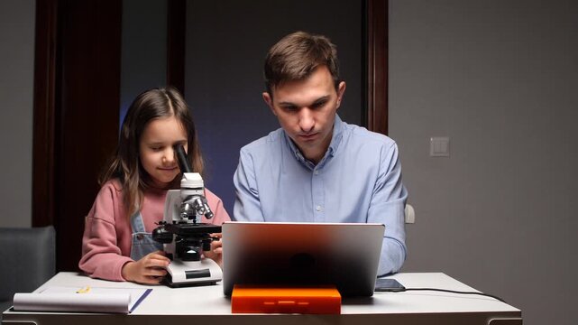 Father and daughter exploring science with microscope and laptop - Powered by Adobe