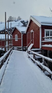 Red wooden rorbu house in fjord in Nusfjord, one of the oldest fisherman village in Norway. Lofoten islands, Norway
