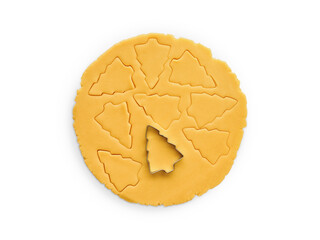Rolled out dough with cut out Christmas tree shapes isolated on white background with clipping path. Design element. Top view. Christmas baking.