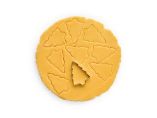 Rolled out dough with cut out Christmas tree shapes isolated on white background with clipping path. Design element. Top view. Christmas baking.