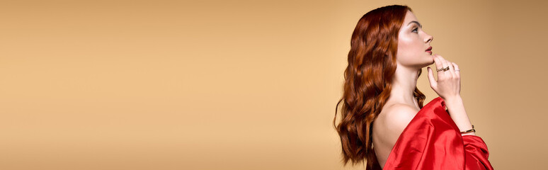 Young redhead woman in a red dress celebrates the joy of the holiday season