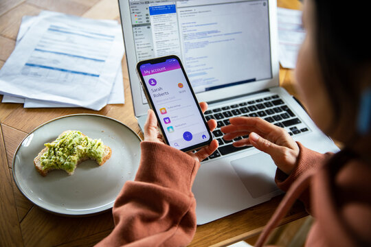 Young adult using smartphone and laptop at home - Powered by Adobe