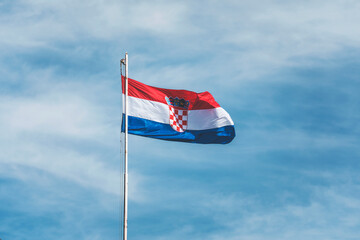 flag of croatia in pula, in front of the blue sky with clouds