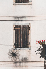 old wooden window in the small town in istria and a flower shaped shadow on the wall