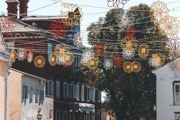 detail of a small square of a little town in istria with lots of flower shaped colorful festoons
