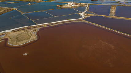 Aerial view of the Trapani salt pans, Sicily, Italy. There are mills among the waters of the salt evaporation ponds, with their characteristic red color.