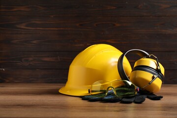 Different safety equipment on wooden table. Space for text