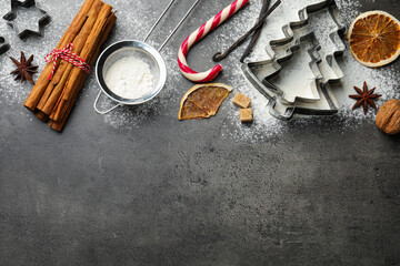 Christmas composition with rolling pin, cookie cutters and spices on grey table, flat lay. Space...