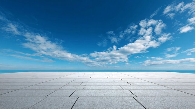Expansive concrete floor meets infinite blue sky with soft white clouds, creating a minimalist landscape of geometric precision and ethereal openness - Powered by Adobe