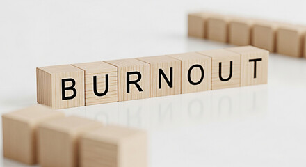 Wooden blocks spelling burnout on a white surface represent workplace stress and the importance of mental health and work life balance