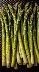 Fototapeta premium Fresh green asparagus spears ready for cooking with a sprinkle of salt and pepper