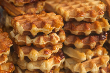 Close up of golden Liège waffle stack with caramelized sugar and rich texture, traditional Belgian sweet treat for breakfast or dessert.