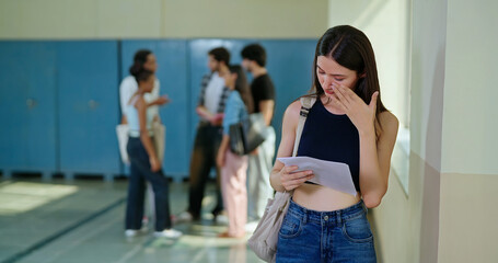 Indian young adult gen z upset sad woman lady feel bad hold report paper in hand campus place teen...