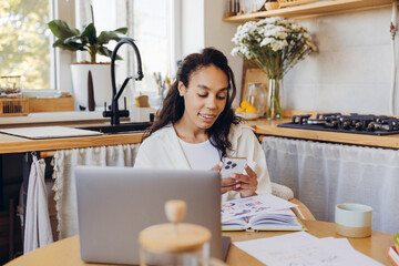 Confident, smiling African American woman, businesswoman holding mobile phone, using mobile app
