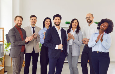 Interracial joyful young team clapping hands for business man, close-up. A multicultural group of...