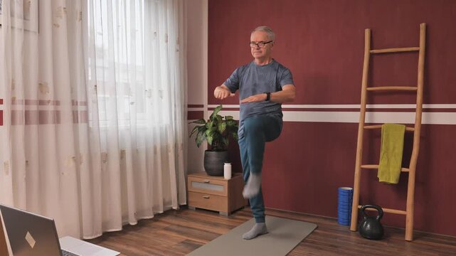 Senior man working out indoors, home fitness routine to stay fit and strong, healthy lifestyle for older adults.