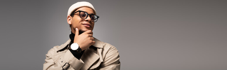 Stylish young man showcasing modern fashion with confidence in a neutral backdrop