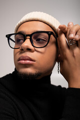 Handsome young man showcases stylish attire and confident pose in a modern setting