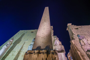 Capture the nighttime beauty of Temple of Luxor in Egypt, featuring an iconic obelisk and statues,...