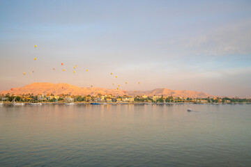 Spring dawn hot air balloons flying above Luxor West Bank Nile River, Egypt 2025 landscape view.