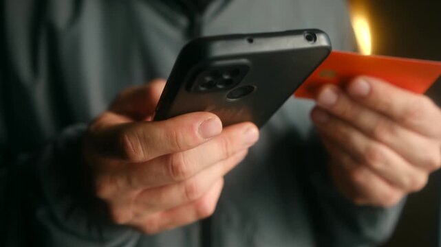 Conceptual scene with a man using a smartphone for online shopping while holding a credit card, symbolizing reckless spending, debt, and financial risk in the digital age. Shopping online concept.