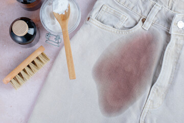 Dirty red wine stain on light denim jeans ready for cleaning with natural ingredients in a home...
