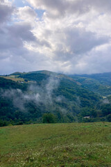 Picturesque landscapes with rolling green hills and mountains in the highlands of Cantabria, Spain.
