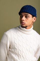 Handsome young man shows off stylish winter outfit with confidence in trendy hat