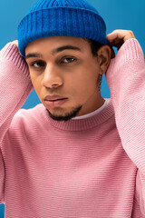 Stylish young man showcases modern fashion with vibrant colors indoors