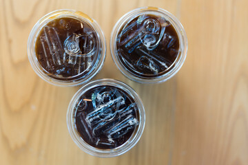 A trio of iced Americano coffee drinks on a table. Top view