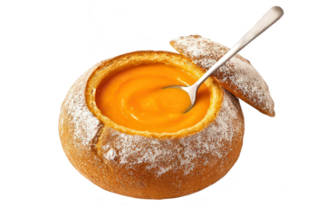 Delicious pumpkin soup served in a bread bowl with a spoon