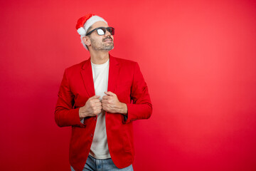 Man in santa hat and sunglasses posing with a red jacket, celebrating festive season
