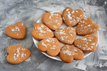 Heart-shaped gingerbread cookies dusted with powdered sugar on the plate