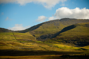 Sunlit mountain ridges and grassy slopes in Snowdonia National Park, Wales