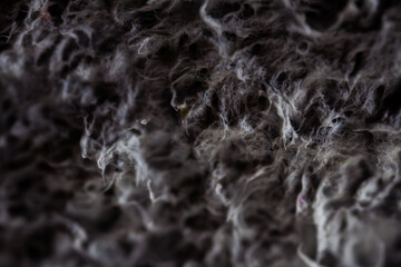 Extreme close up of old gray handmade paper clay with a structure and rough texture. Paper recycling. Selective soft focus, shallow depth of field.