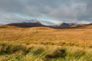 Glencoe, United Kingdom - October 11 2025: Stunning beauty of Glencoe National Park in the Scottish Highlands on a sunny autumn afternoon with mystical-looking mountains shrouded by dramatic clouds
