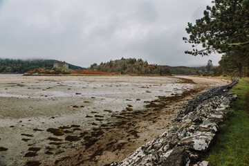 A dramatic and atmospheric photograph of the ruined medieval Castle Tioram (pronounced "Cheerum"), the former stronghold of the Clanranald branch of the MacDonalds - in Loch Moidart